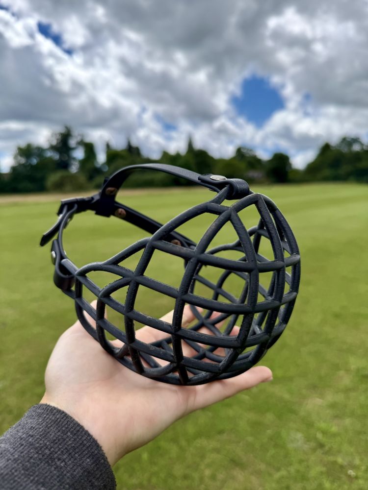 Black custom muzzle held in a hand